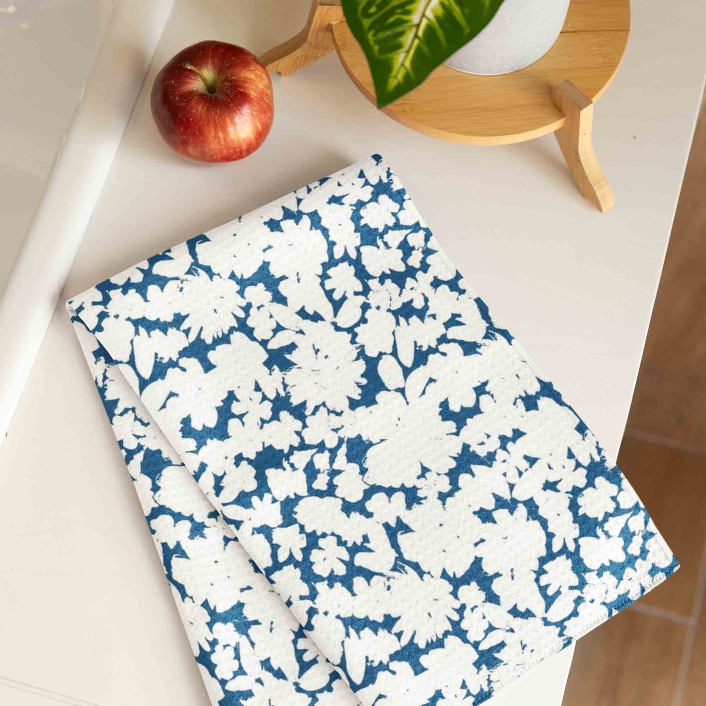A serene and elegant surface design featuring white floral silhouettes set against a rich blue background.
